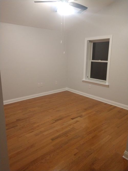 A room with a window and wooden flooring.