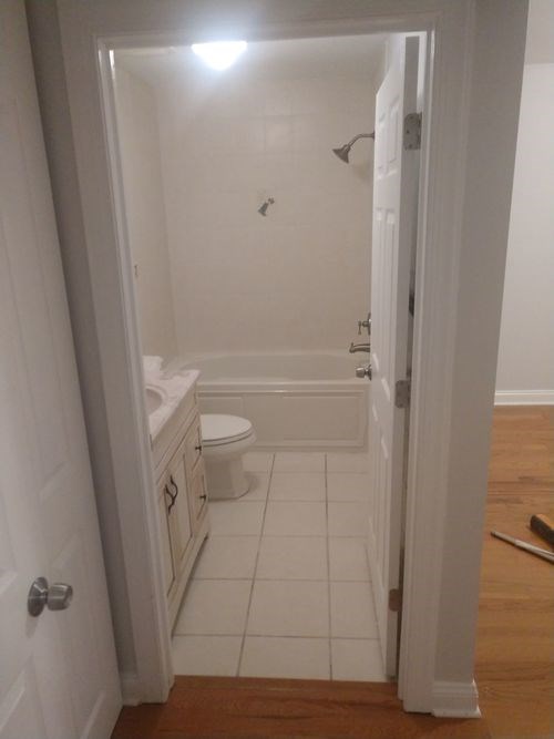 A white bathroom with a toilet, sink and bathtub.