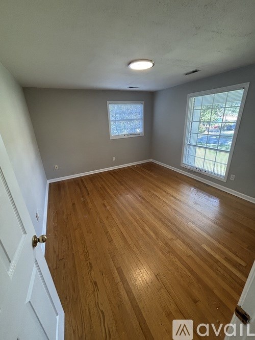 A room with wooden flooring and a window.