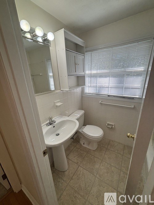 A bathroom with a toilet, sink, and mirror.