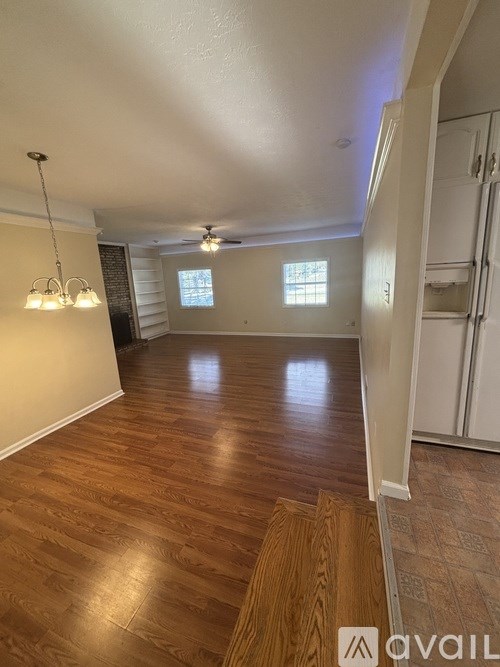 A room with wooden floors and a ceiling fan.