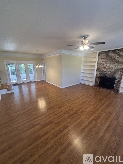 A room with wooden floors and a ceiling fan.
