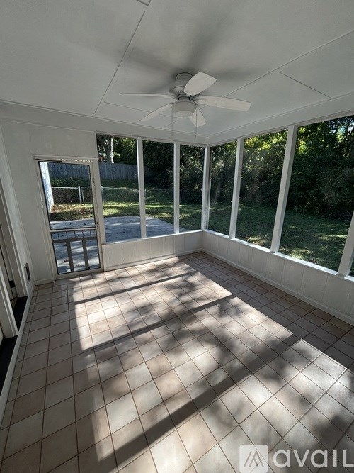 A room with a ceiling fan and tiled floor.
