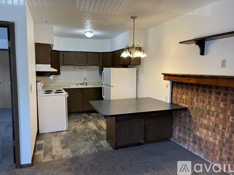 A kitchen with a white dishwasher and wooden cabinets.