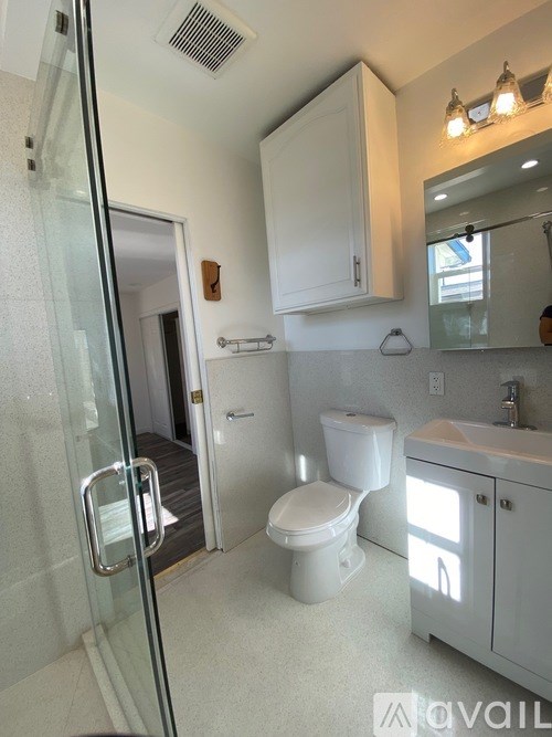 A white toilet and sink in a bathroom.