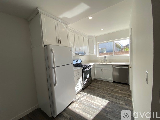 A kitchen with a refrigerator, stove, and sink.