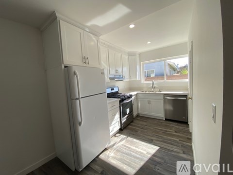 A kitchen with a refrigerator, stove, and sink.