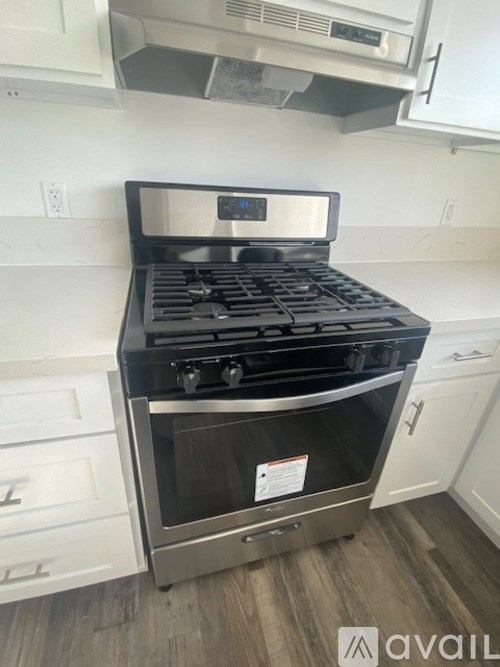 A stainless steel gas range with a digital display in a kitchen.