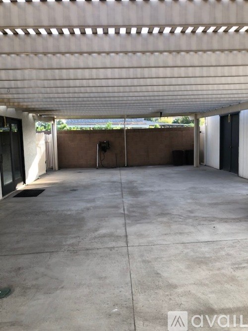 A large, empty, concrete-floored garage with a white ceiling and a wall of windows.