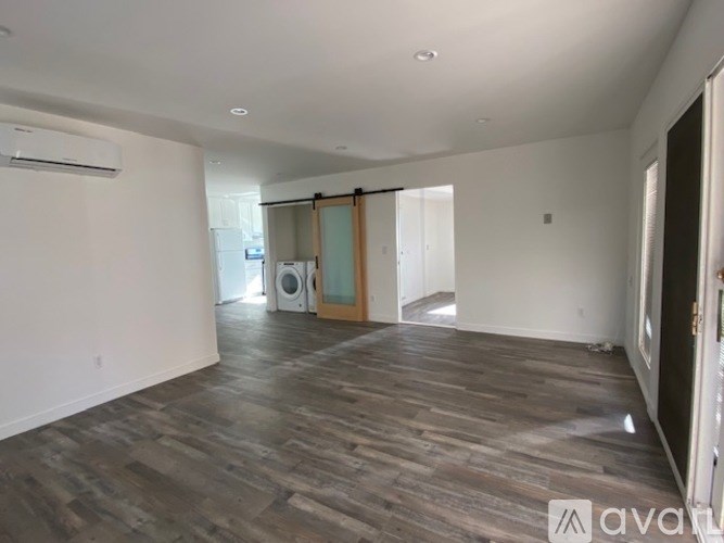 A room with wooden flooring and a sliding glass door.