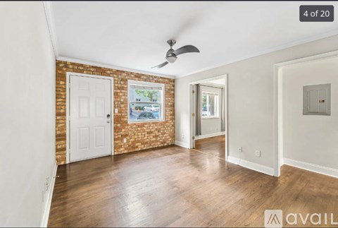 A living room with a couch and a branch on the wall.