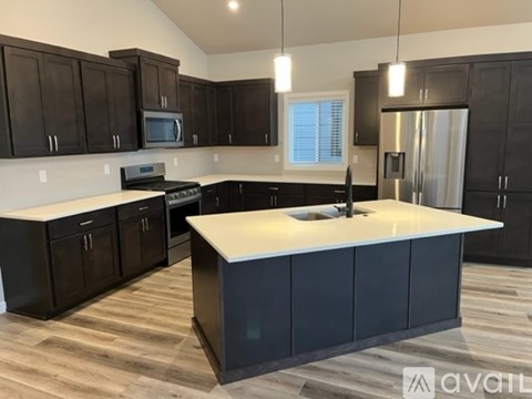A kitchen with dark wood cabinets and a white island.