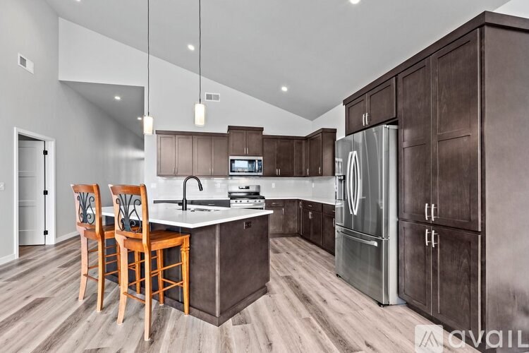 A kitchen with wooden floors and a refrigerator.