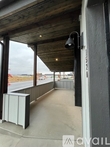 A wooden covered walkway with a bench and a lamp.