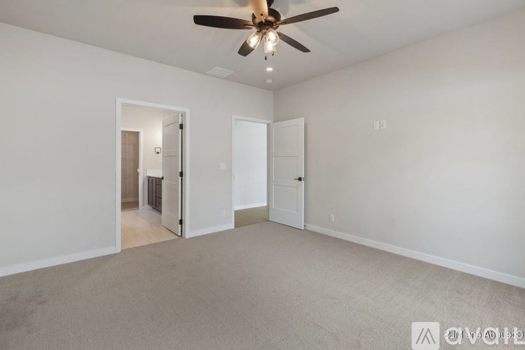 A room with a ceiling fan and two doors, one of which is open.