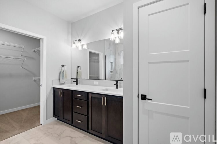 A bathroom with a vanity, mirror, and a white door.