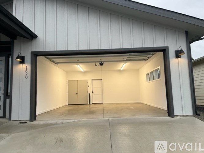 A large garage with a white exterior and a black roof.