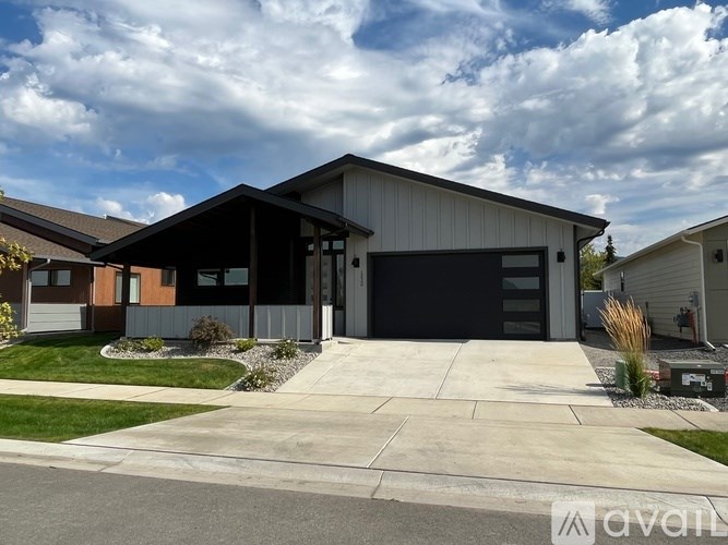 A modern house with a large garage door is for sale.