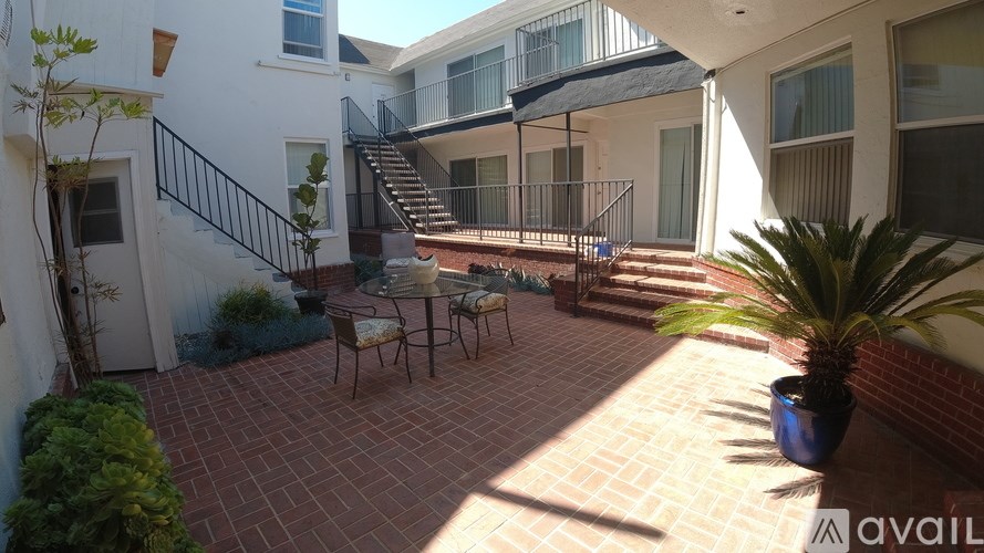 A patio with a table and chairs is surrounded by a brick wall.