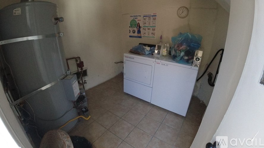 A small room with a white cabinet and a large metal tank on the left.