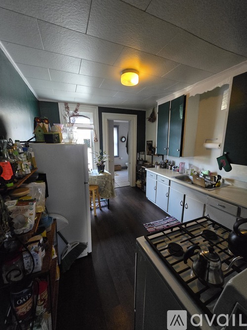 A kitchen with a stove top oven and a refrigerator.