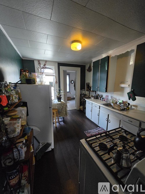 A kitchen with a stove top oven and a refrigerator.