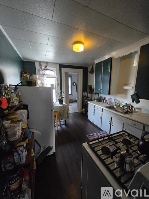 A kitchen with a stove top oven and a refrigerator.