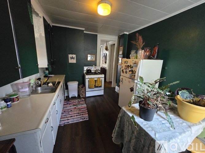 A kitchen with green walls and a white refrigerator.