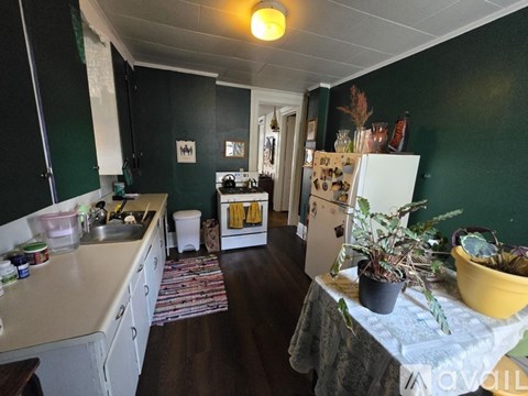 A kitchen with green walls and a white refrigerator.