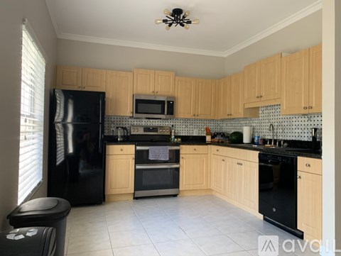 A kitchen with wooden cabinets and black appliances.