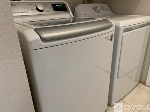 A white dryer and washer are next to each other.