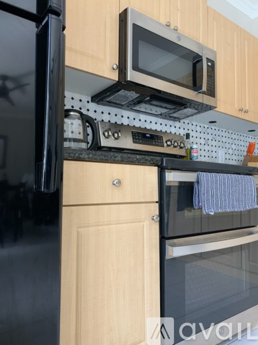A kitchen with wooden cabinets and black appliances.
