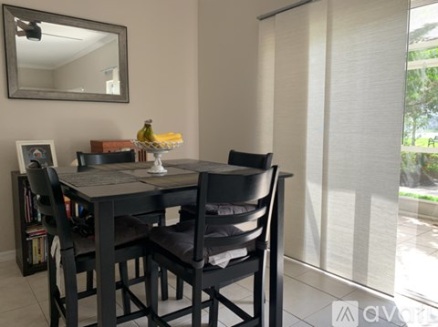 A dining table with four chairs and a mirror above it.