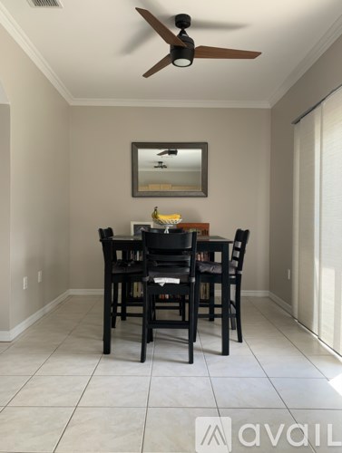 A dining room with a table and chairs.
