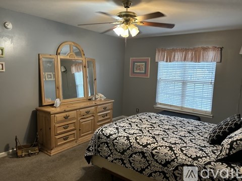 A bedroom with a bed, dresser, and mirror.