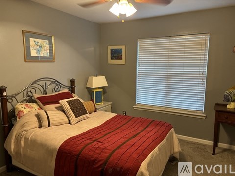 A bedroom with a bed, nightstands, and a ceiling fan.
