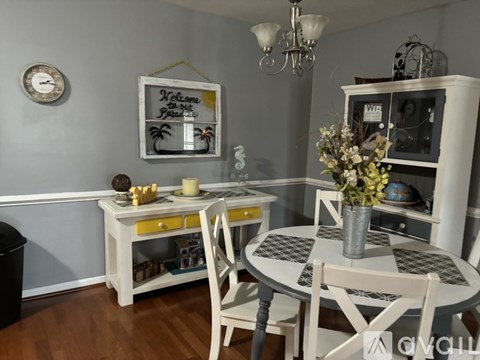 A dining room with a white table and chairs.