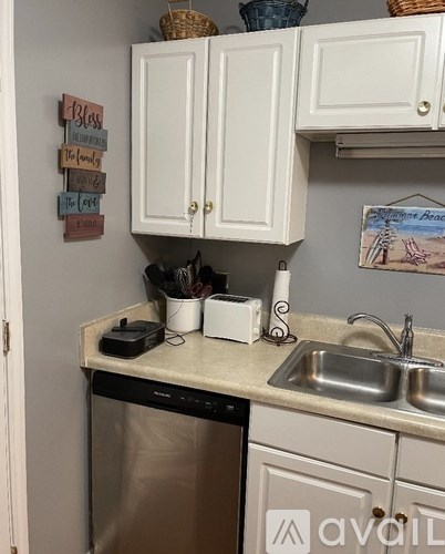 A kitchen with a white sink and a dishwasher.