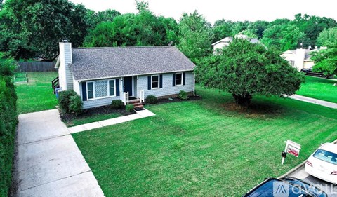 A house with a white car parked in front.