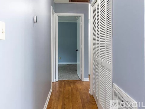 A hallway with a doorway leading to another room.