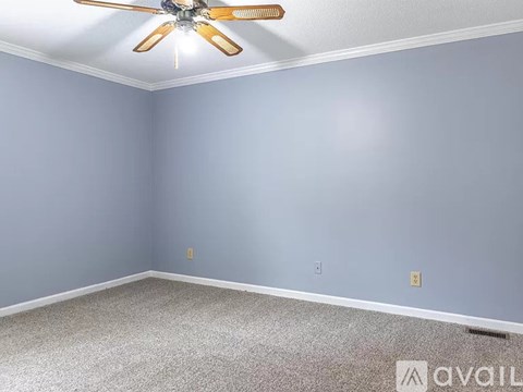 A room with a ceiling fan and carpeted floor.