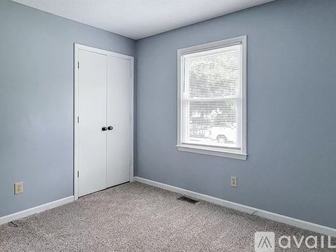 A room with a white door and a window with blinds.