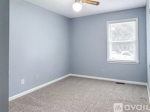 A room with a window and a ceiling fan.