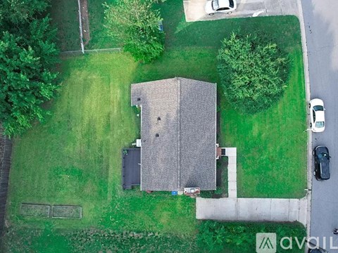 A house with a grey roof is surrounded by a green lawn.