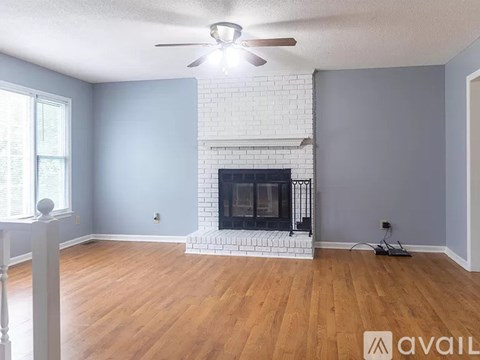 A living room with a fireplace and a ceiling fan.