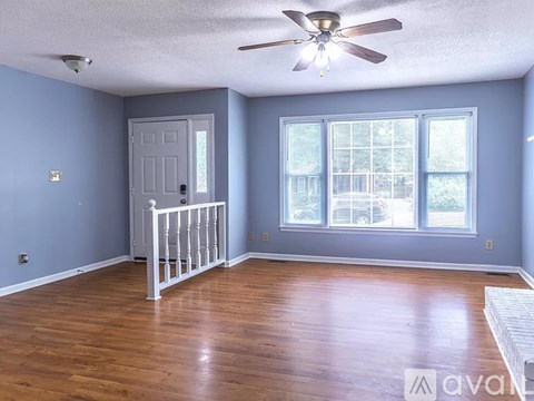 A room with a ceiling fan and a white crib.