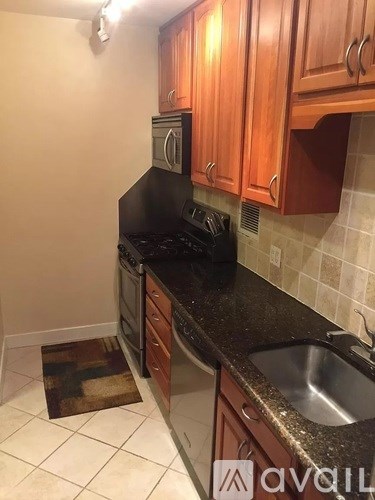 A kitchen with wooden cabinets and black appliances.