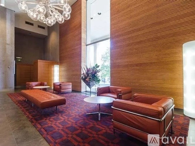A large room with a red carpet and brown leather furniture.