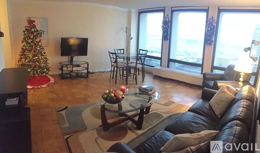 A living room with a Christmas tree and a flat screen TV.