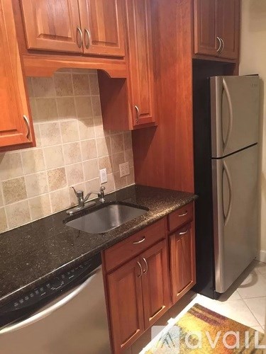 A kitchen with wooden cabinets and a black counter top.